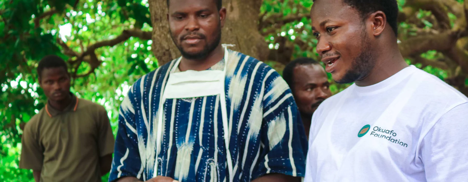 Okuafo Foundation team members meeting with a community group outdoors